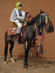 Fulani rider and horse with traditional harness saddle reins and stirrup leathers
